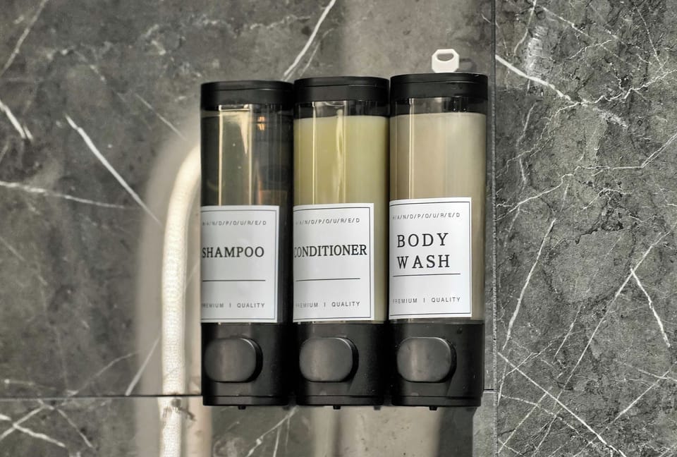 Wall-mounted shampoo and body-wash dispensers.