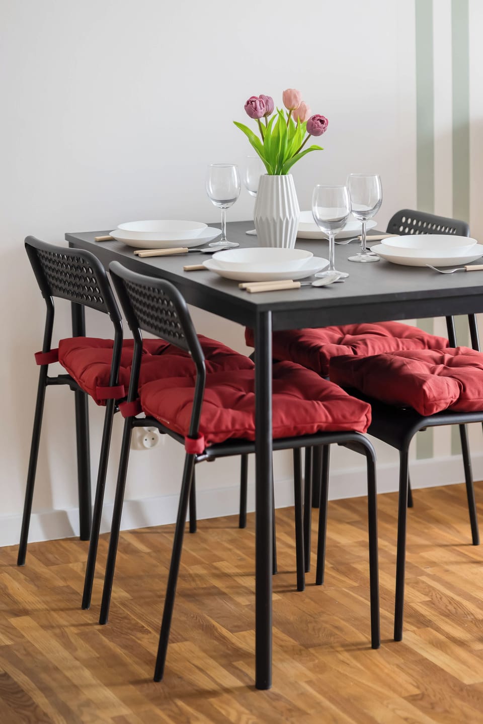 A combined living and dining space showing a sofa on one side and a dining table on the other. Large windows provide ample illumination throughout the entire area.