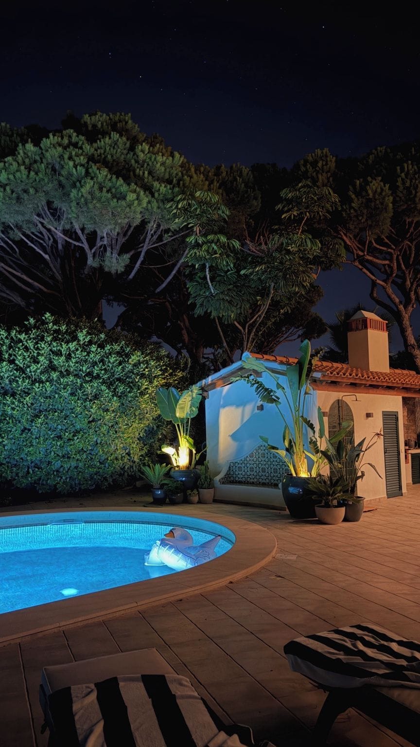 The private pool after dark, with illuminated water and softly lit greenery.