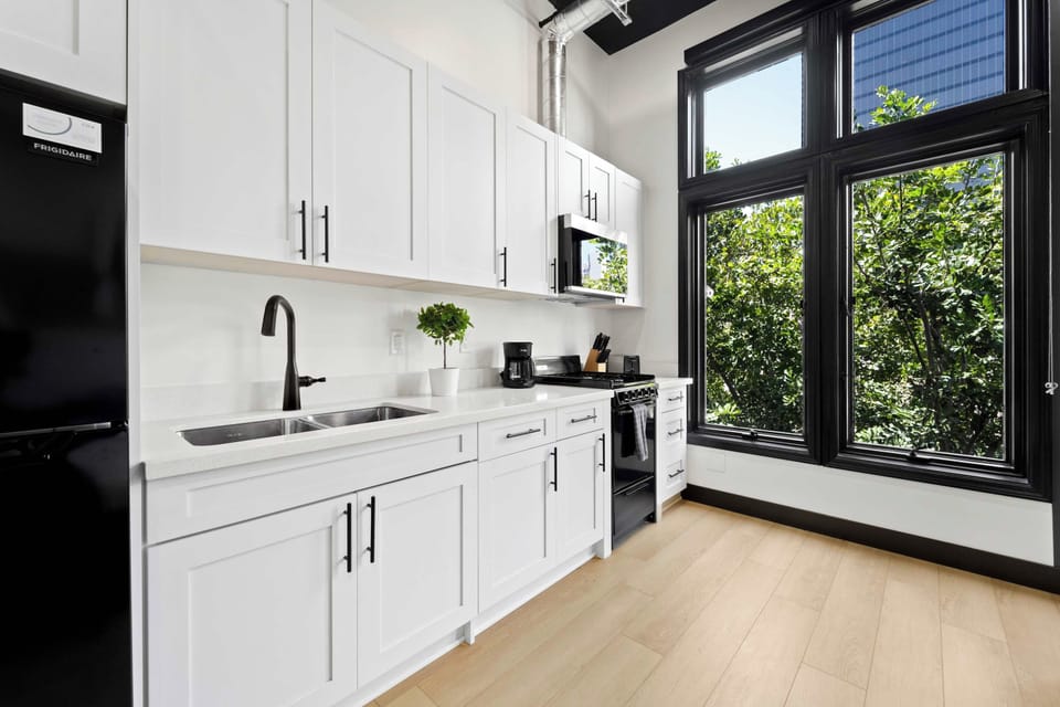 🌳 Kitchen framed by garden views—full-size appliances and ample counter space, all with greenery just outside.