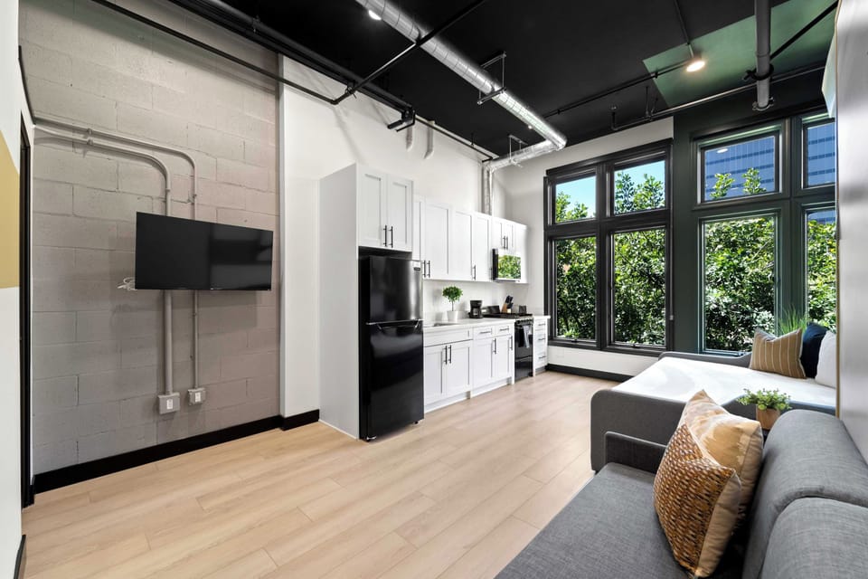 🌆 Open kitchen and lounge with skyline glimpses through the trees—a bright, functional space to cook and unwind.