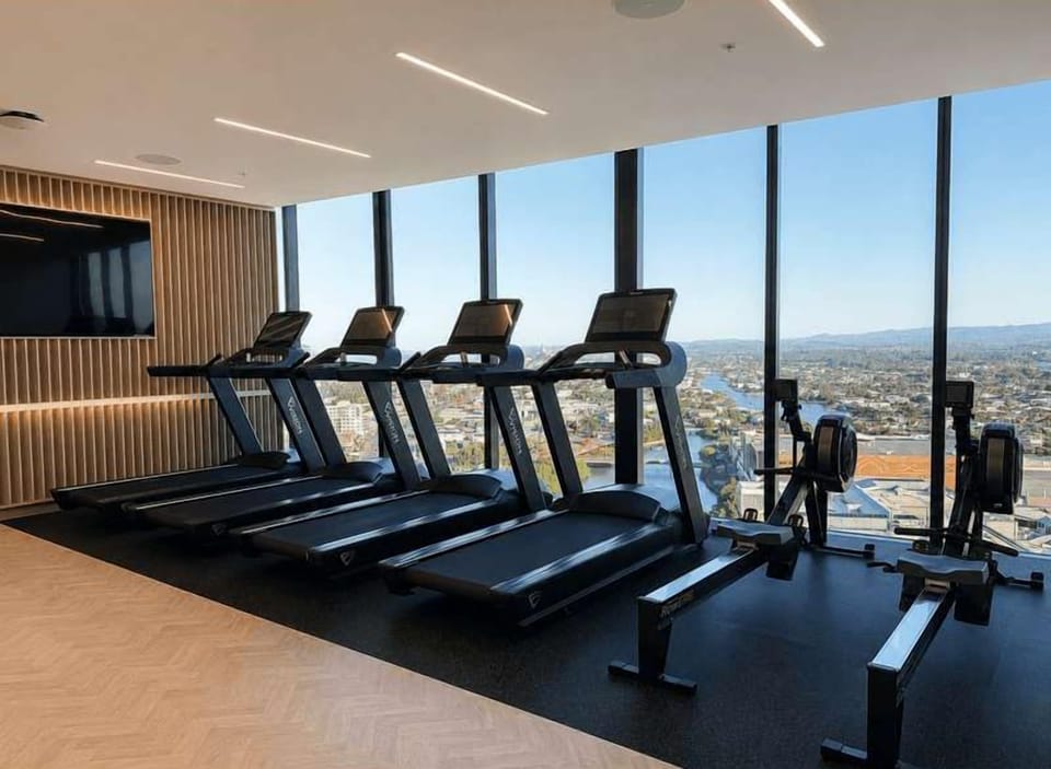 Work out in the state-of-the-art gym equipped with a row of treadmills facing double-height floor-to-ceiling windows