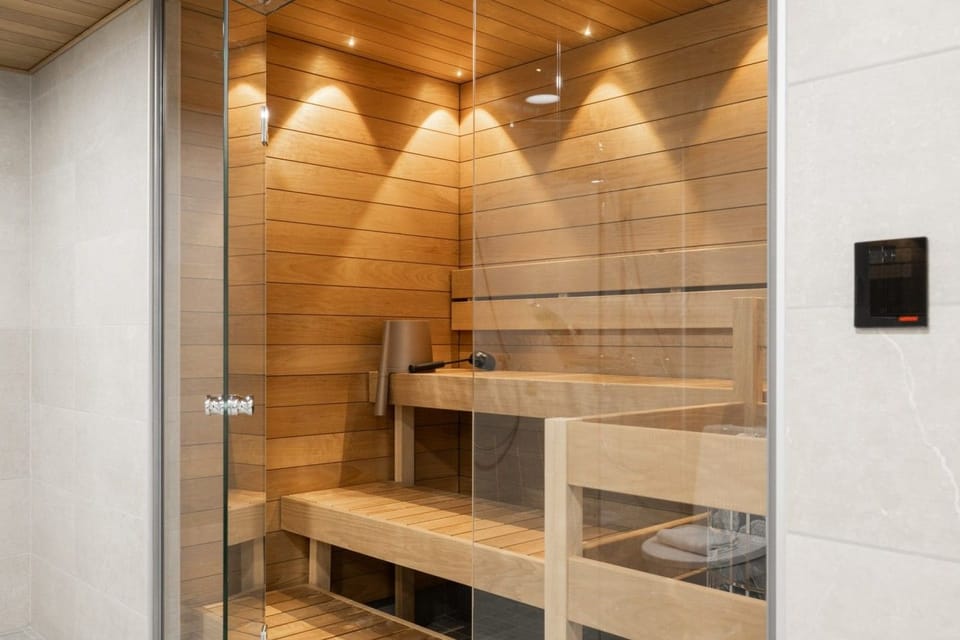 Modern sauna with warm wooden benches and ambient lighting for a relaxing retreat.