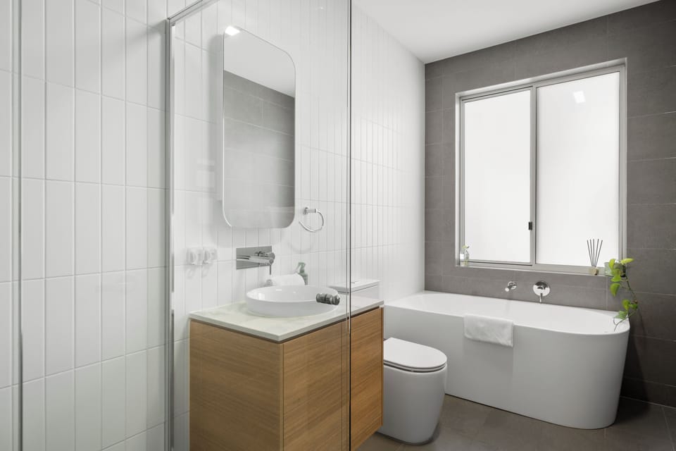 Indulge in a soothing soak in the freestanding bathtub or refresh beneath the separate shower, with a contemporary timber vanity completing the space.