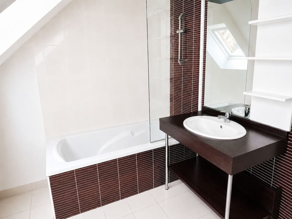 Salle de bain à l`étage avec baignoire, parfaite pour se détendre après une journée de découverte