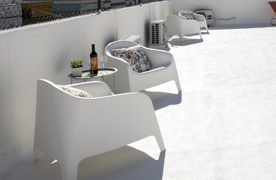 Sunny rooftop lounge with modern seating and a relaxing wine setup