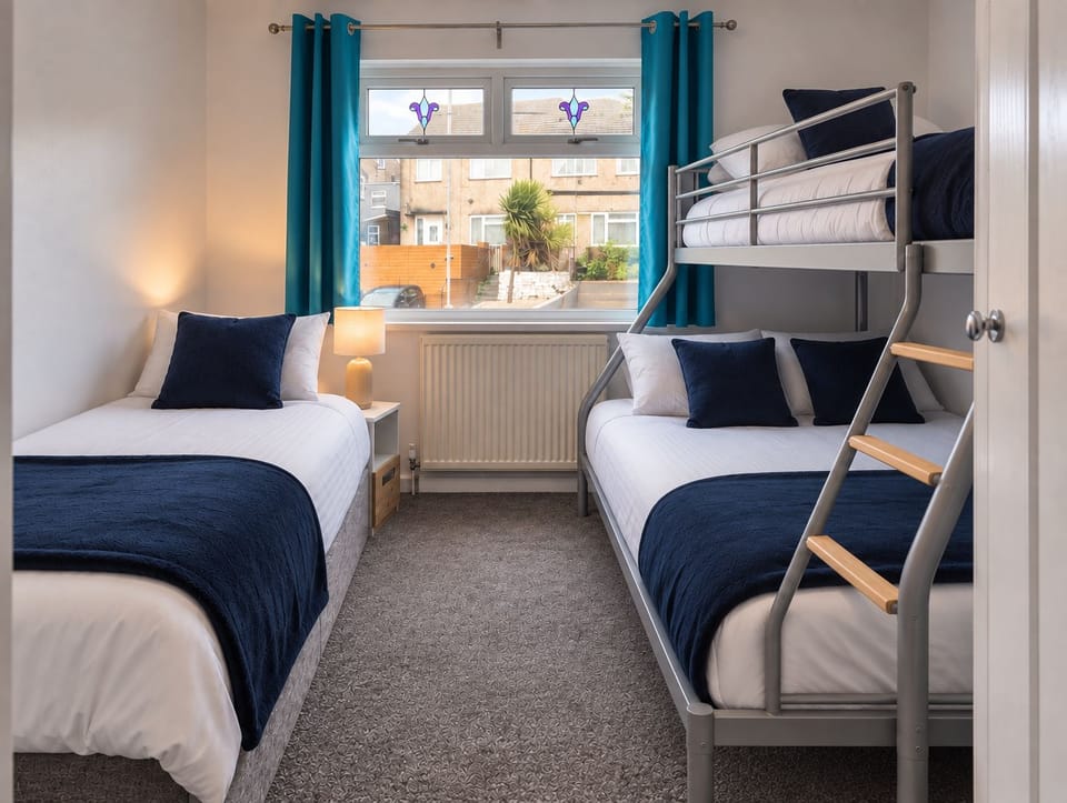 Bright family bedroom with bunk beds, twin bed, and stylish blue accents