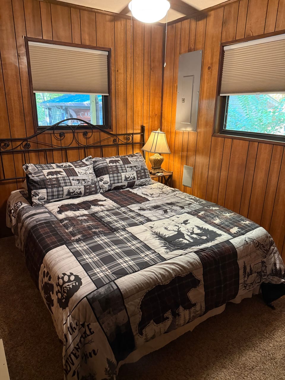 Bedroom with wood-paneled walls and a bed featuring wildlife-themed bedding.