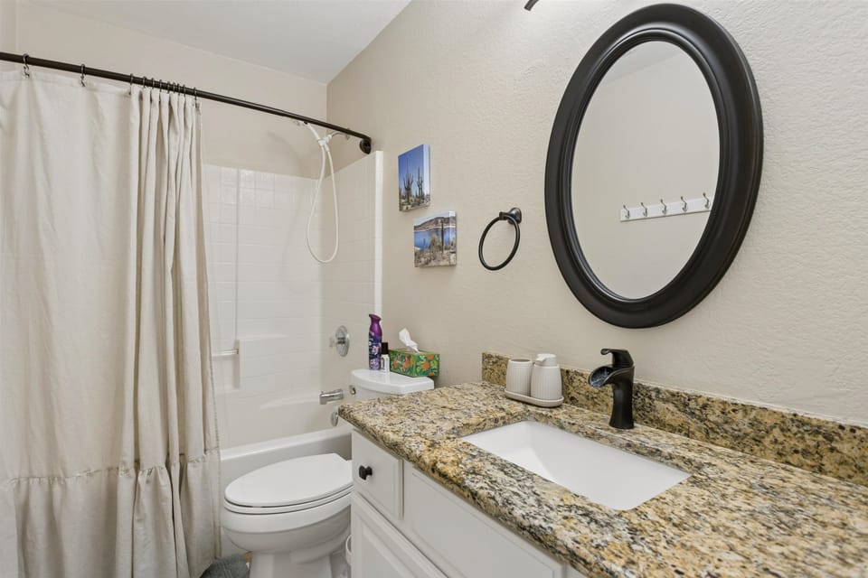 A shared guest bathroom with a shower and bathtub.