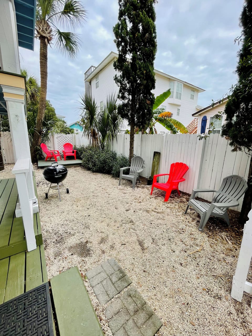 Condo's fenced-in yard & deck with seating and charcoal grill. 
