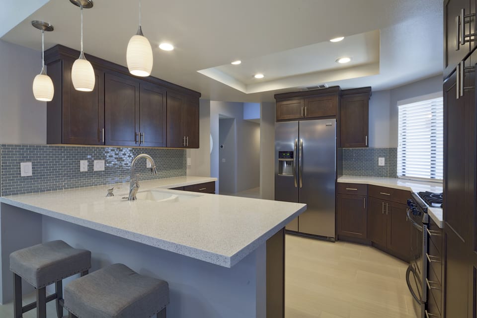 Open kitchen with pendant lighting and seating at the bar!