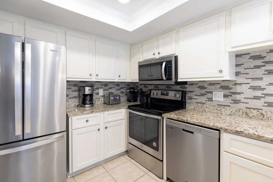 Granite countertop and stainless appliances - refrigerator, stove, dishwasher. 