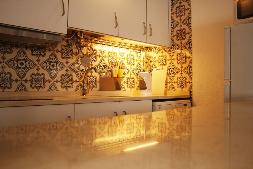 Kitchen equipped with a Microwave, Washing Machine, Electric stove, Kettle.