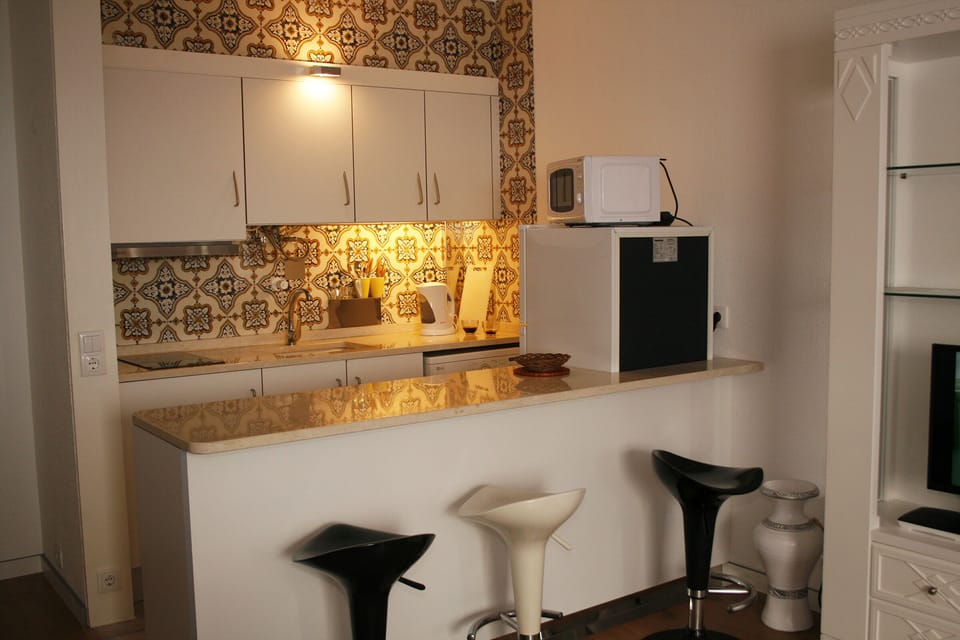 Kitchen equipped with a Microwave, Washing Machine, Electric stove, Kettle.