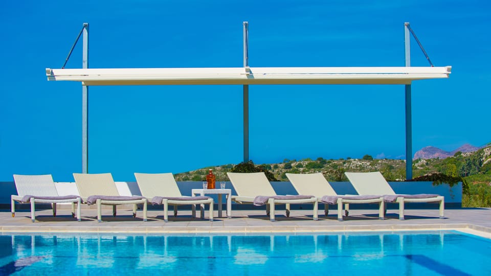 The pool area with a large pergola. The swimming pool is heated on demand.