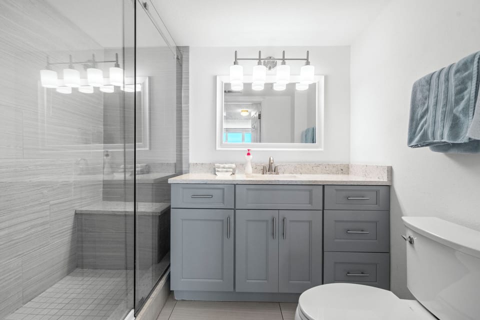 Renovated Master Bathroom with modern shower, tile, and vanity