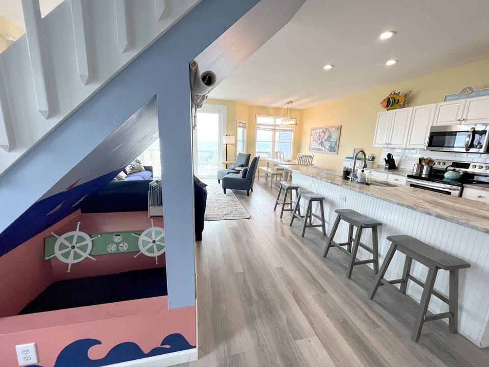 Main floor with fully equipped kitchen, dining area, kids pretend play area