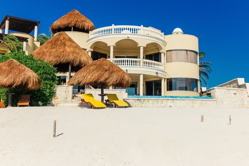 white sand private beach, palapas with teak lounge chairs 