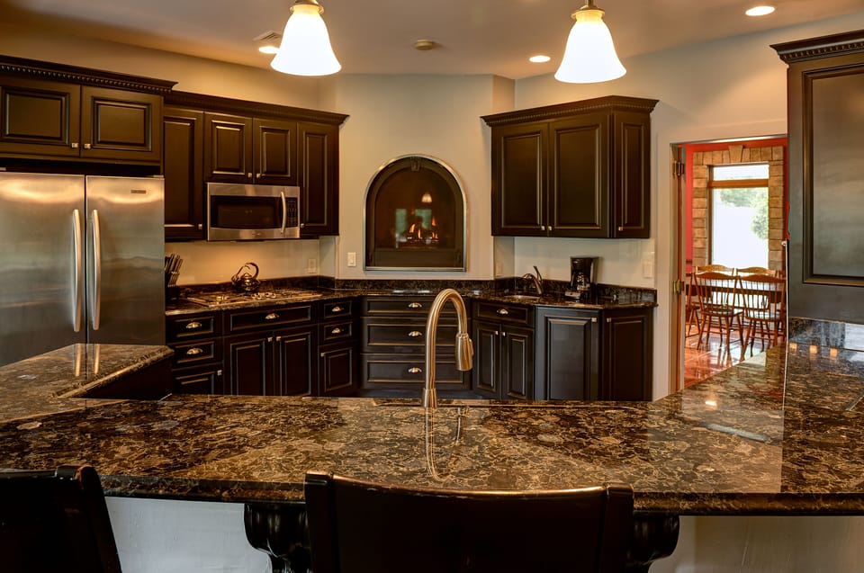 Kitchen with long counter seating, looking into formal dining room.