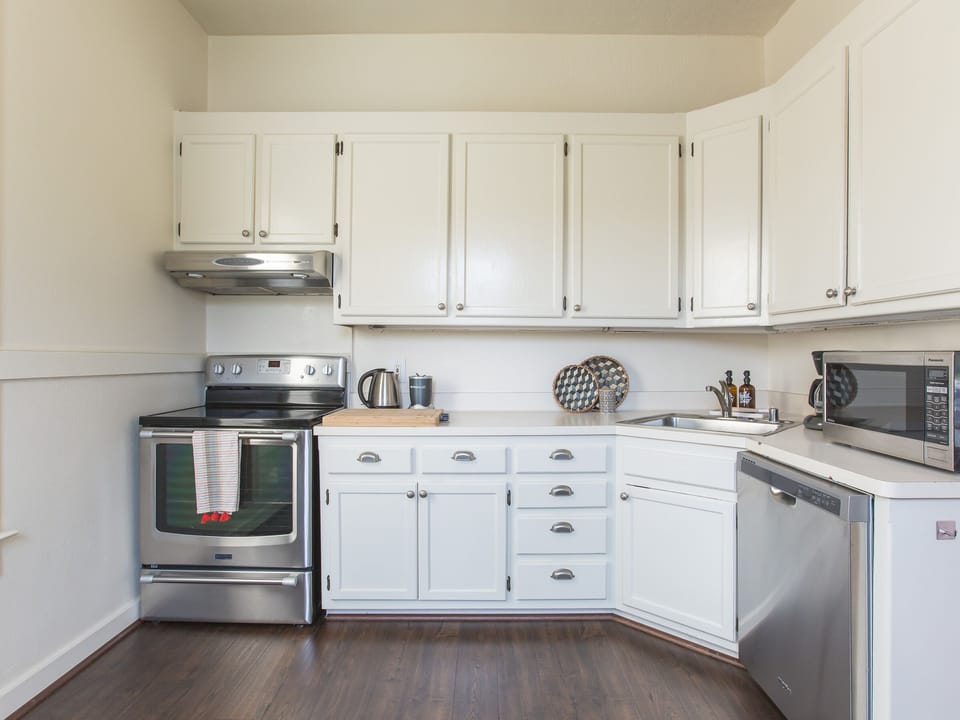 Pantry is stocked with spices, oils and condiments. Pro cutlery, stemware + 