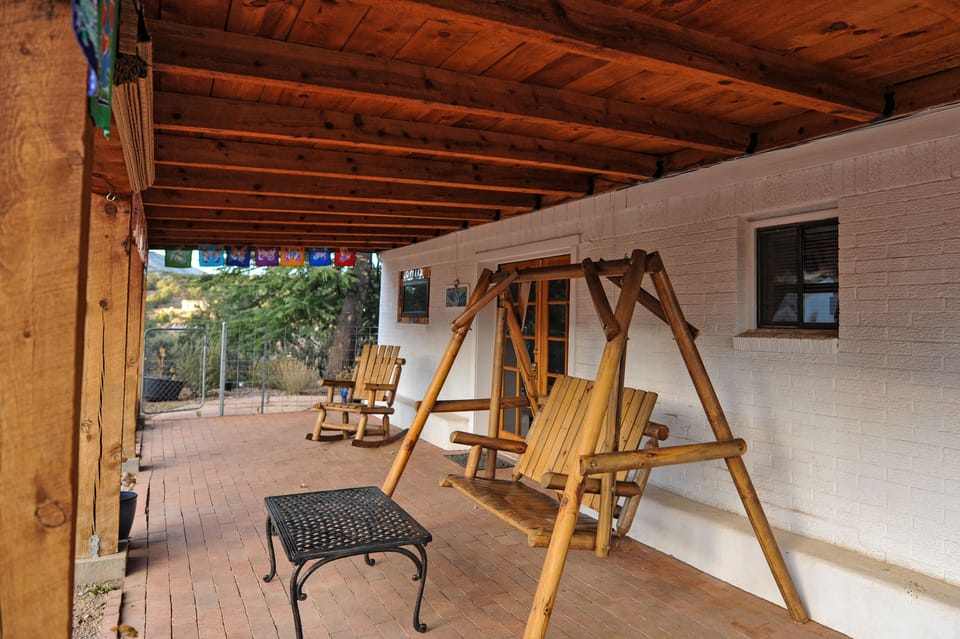 swinging bench and rocking chair on front porch