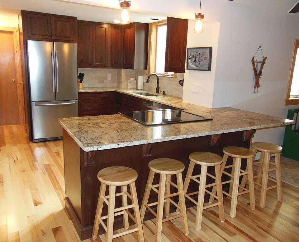 Open concept kitchen with granite counters, stainless appliances.