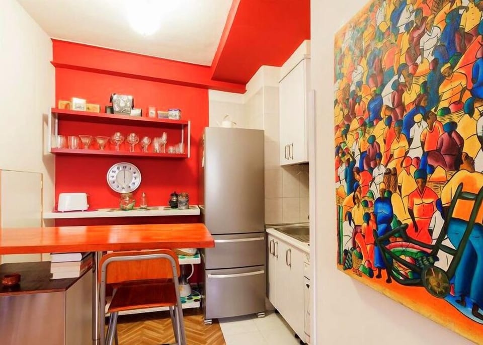 Kitchen with high table, bar stools and fridge/freezer combination.
