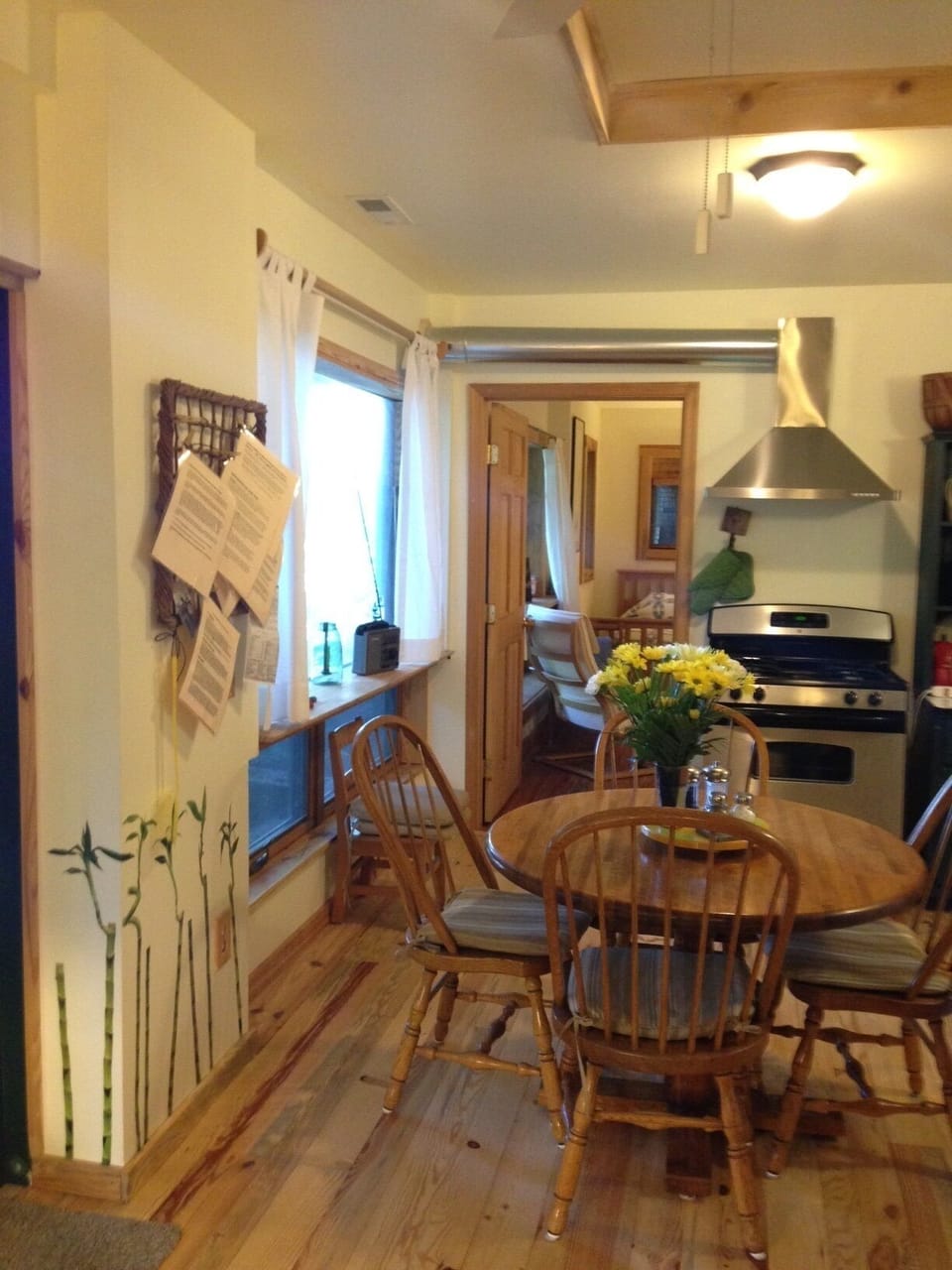 View of dining area and looking toward yellow bedroom. Information board on left