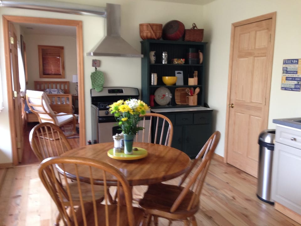 Dinning area with pine table and chairs looking toward the yellow bedroom.