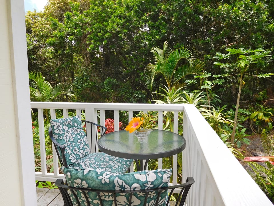 Small lanai for breakfasting surronded by papayas and flowers.