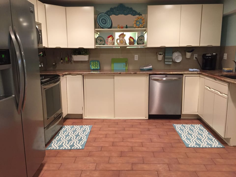 Many cabinets filled with spices, condiments, dishes, glasses, pots and pans.