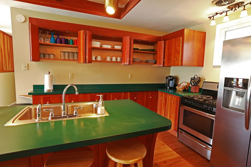 Kitchen fully stocked with dishes, cookware, glasses, silverwear, and coffee pot
