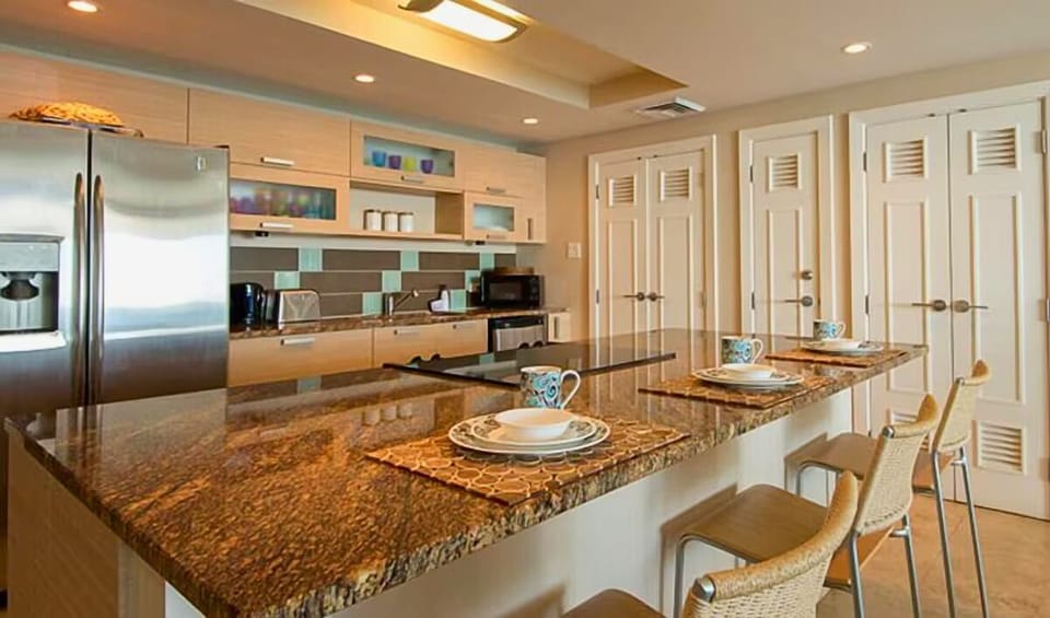 Air-conditioned kitchen with stainless steel appliances and a space for meal. 