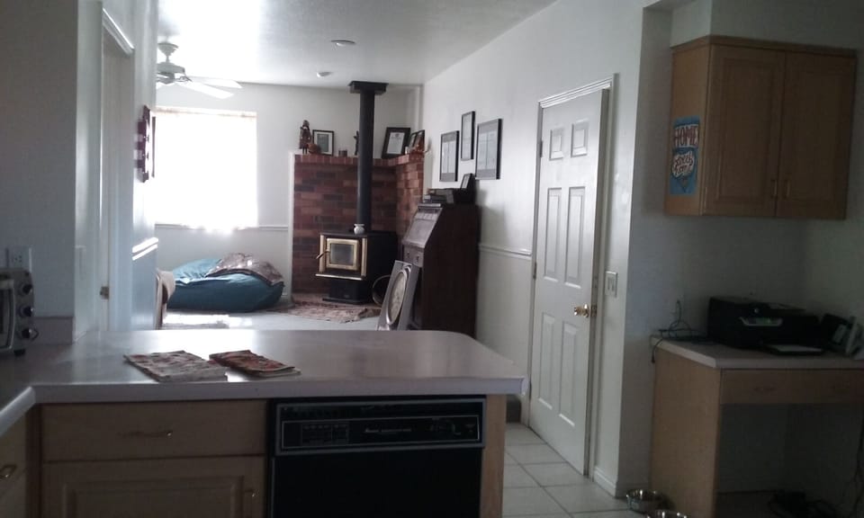 Family room off kitchen with  big screen tv and wood burning stove.