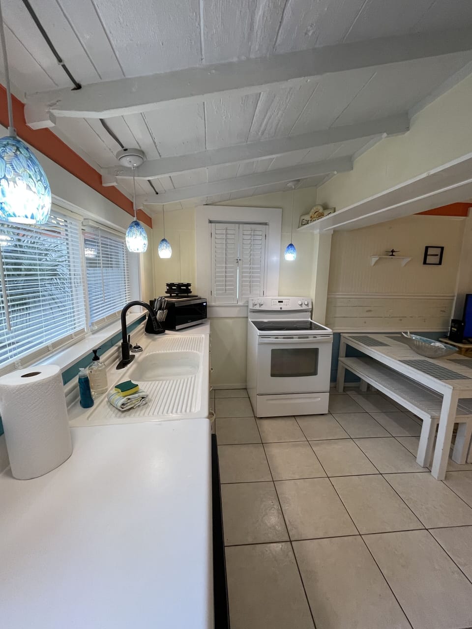 Kitchen w/ original sink from early 1900s. Dining table on left. 