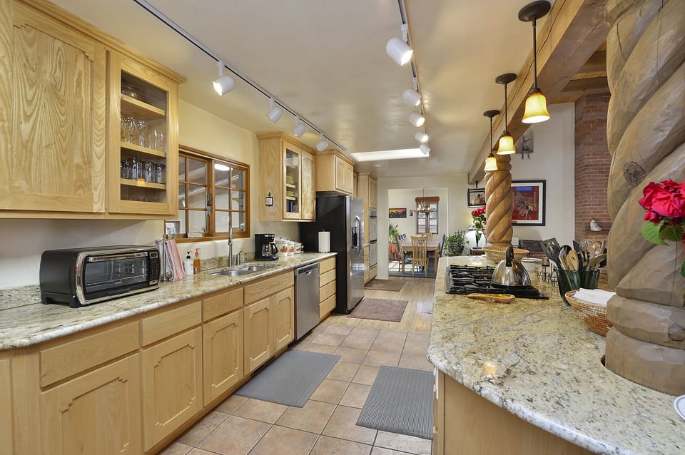 View of beautiful granite Kitchen with Dining room in background. Gas cook top.