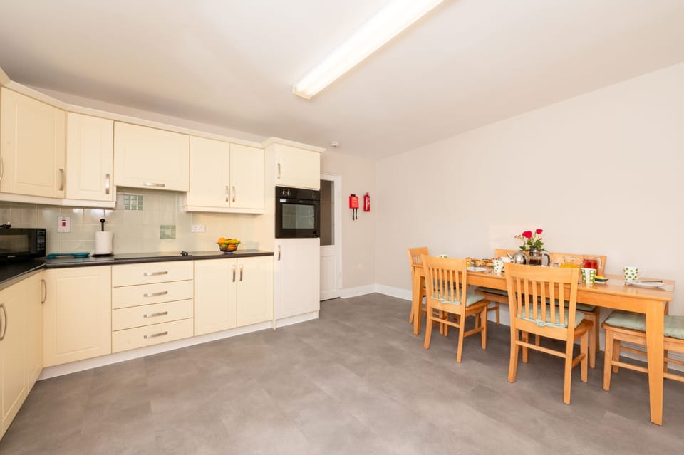 Spacious Kitchen: glass hob, single oven, microwave, dishwasher, dining table.