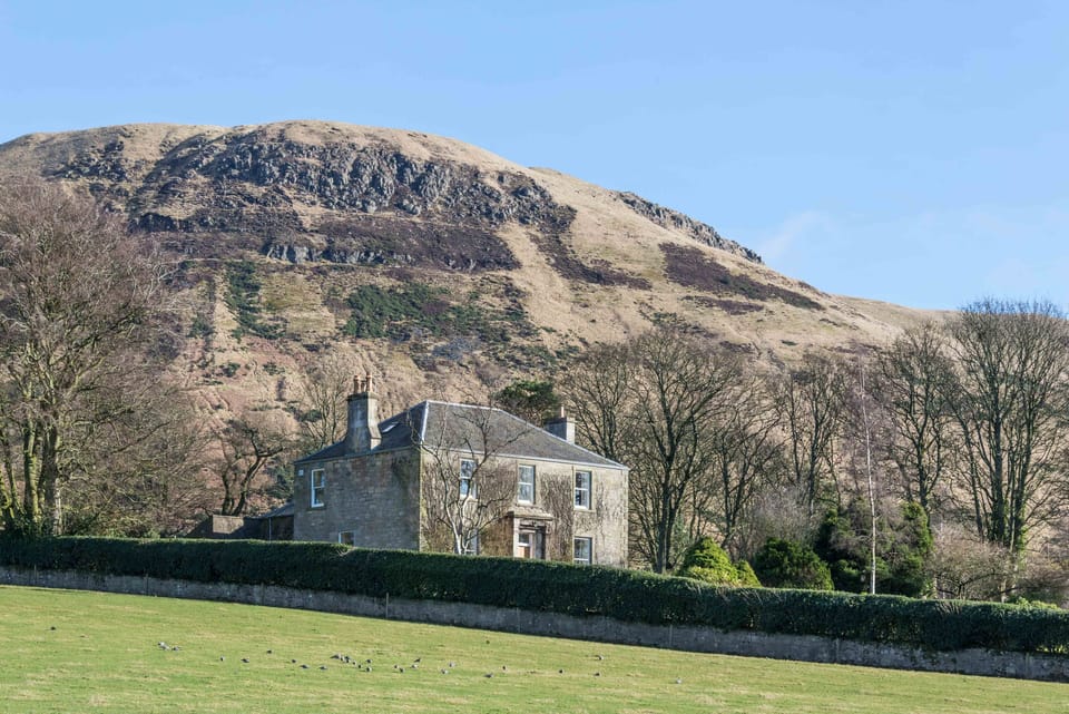 Balgedie House with the Lomond Hills behind in winter. 