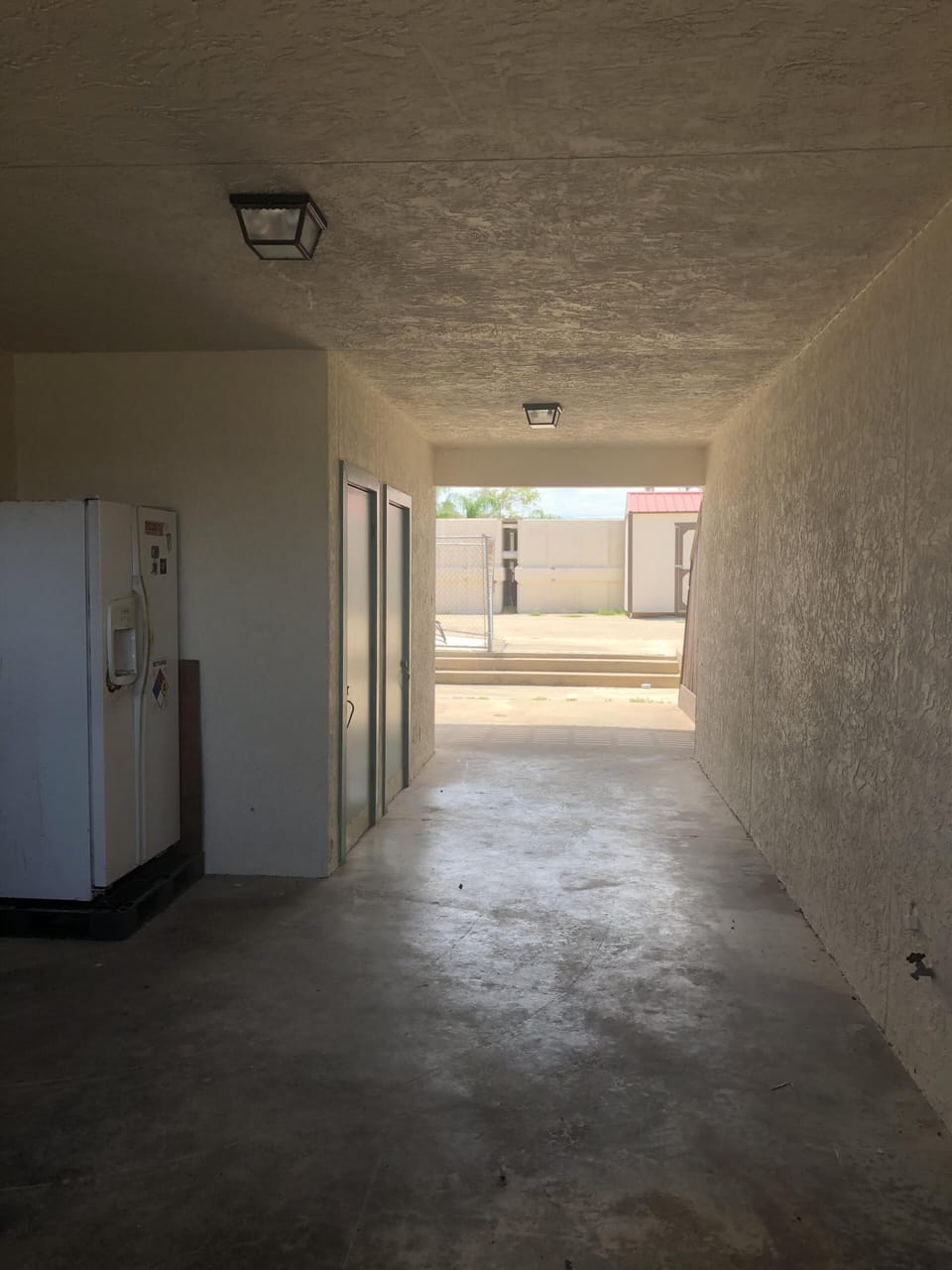 Downstairs breeze way leads to water, boat slip, pool, and cleaning table. 