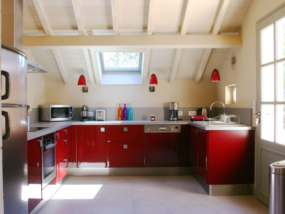 Elegant Burgundy cabinets of the sunny kitchen. French door opens onto the patio