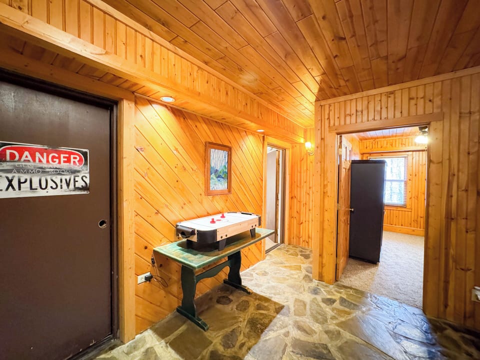 lower level foyer area. complete with tabletop Air hockey and dart board. There is a washer and dryer in the old ammo room - now labeled "Danger Explosives".