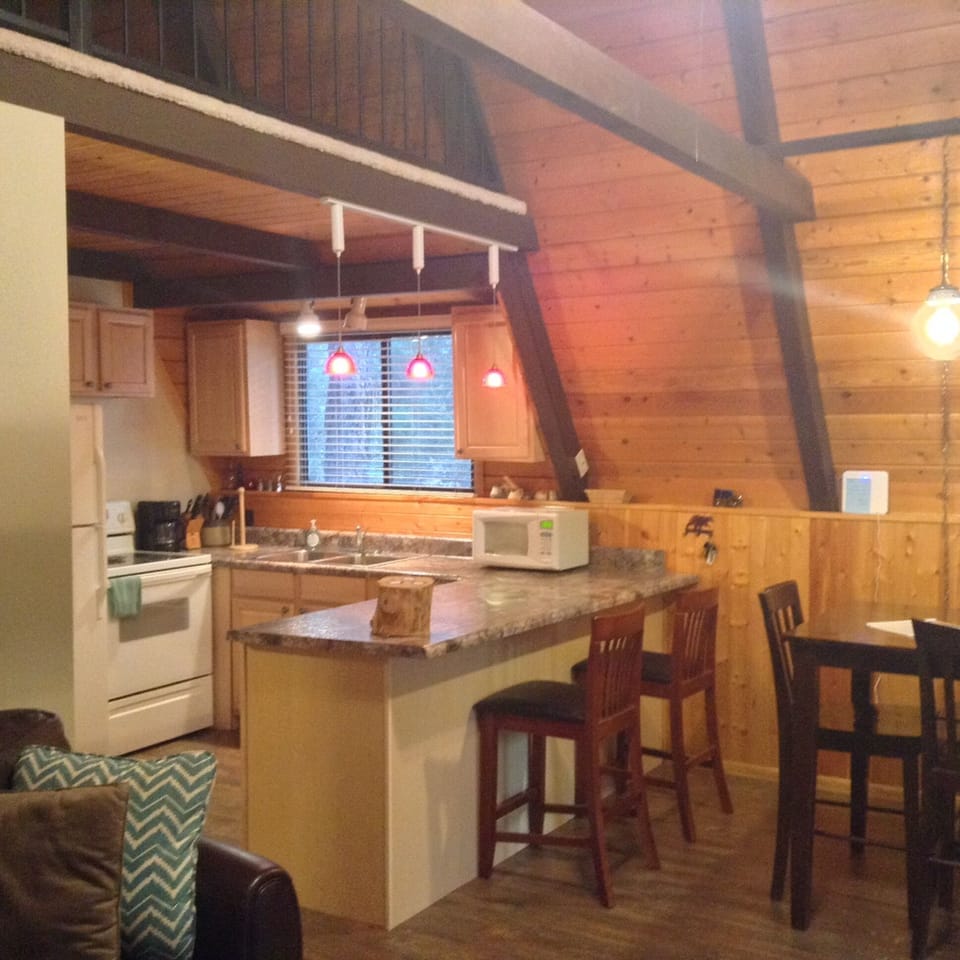 Kitchen with cooking utensils, dishes, microwave, stove and fridge.