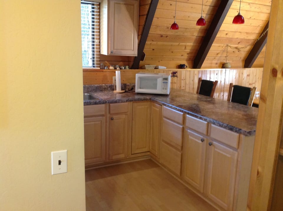 Kitchen with microwave, fridge, stove and all cooking utensils.