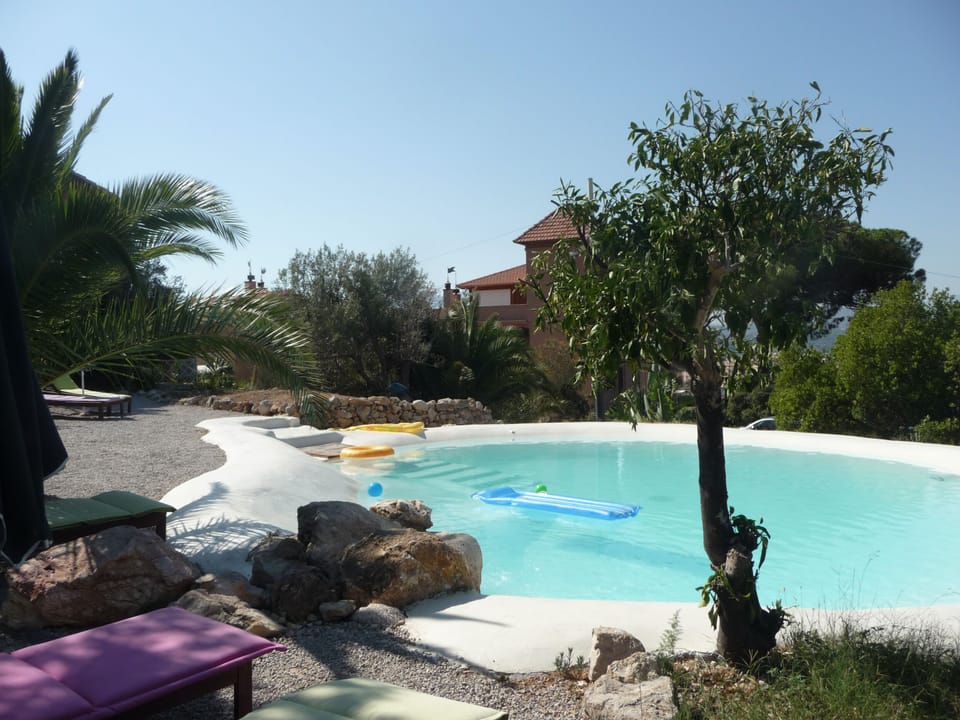 Natural lake-shaped pool in the middle of a Mediterranean garden 
