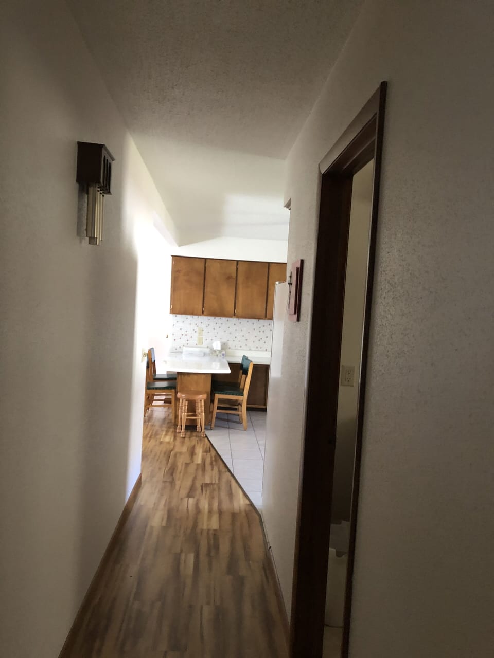 Hallway.  Standing near bedroom looking into kitchen.  Bathroom door on the righ