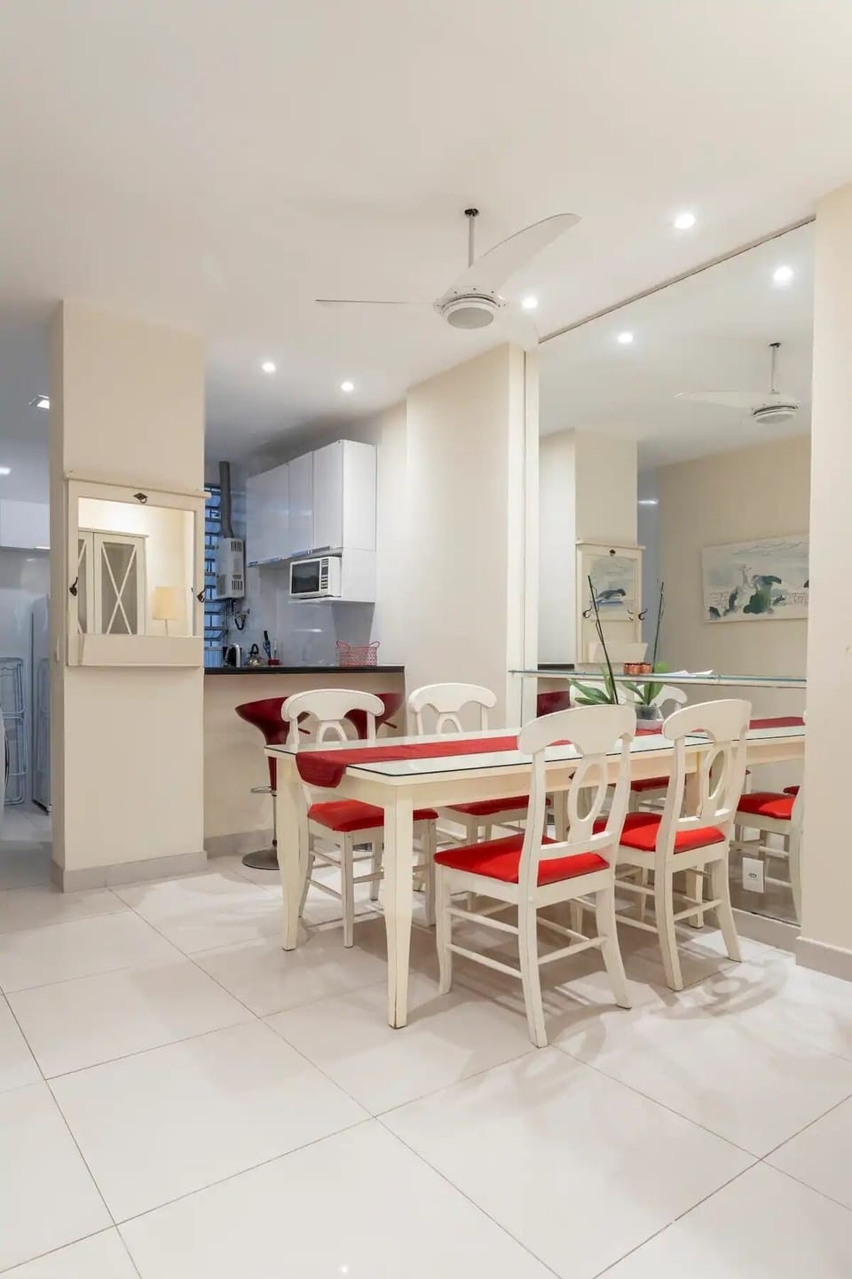 Dining room with large glass covered table and 4 chairs