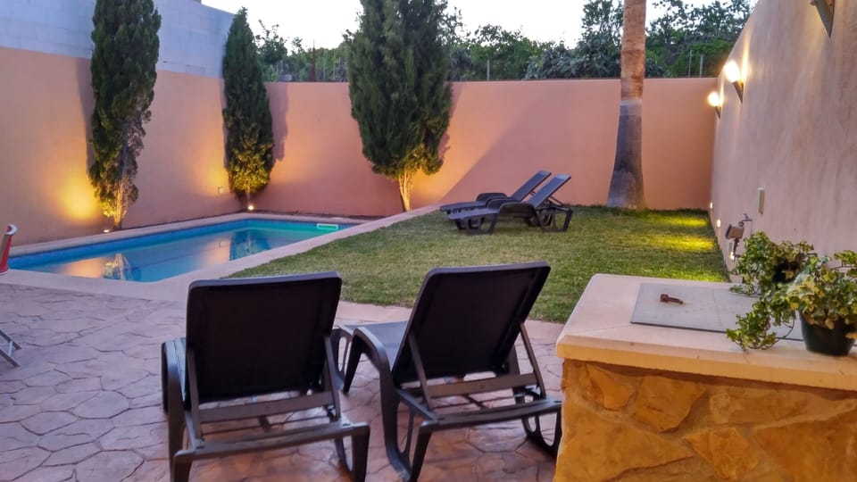 Chill out by the pool on the grass or the terrace. This is a well on the right