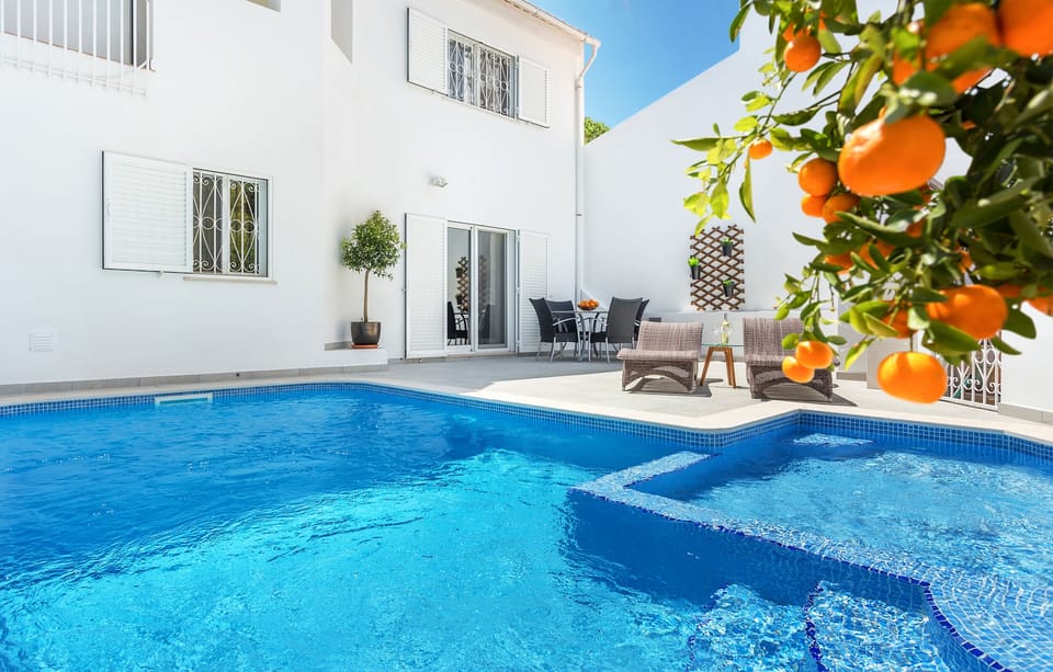 Outside area featuring a heated pool with a kids section, bbq, and lounge area