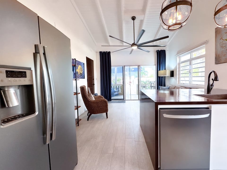 The kitchen is airy and bright, featuring stylish navy and white cabinets that add a fresh coastal feel - creating a cheerful space that is as functional as it is inviting.