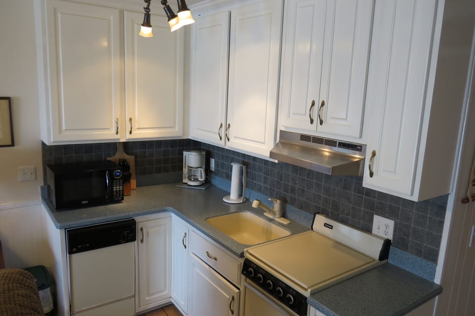 Kitchen has DW, microwave, electric range/ oven, coffee maker, full size fridge.